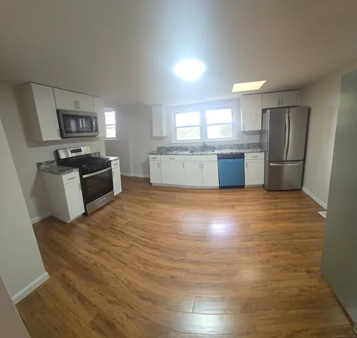 a large kitchen with a stove a refrigerator and a sink