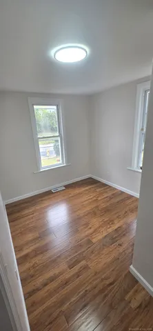 wooden floor in an empty room with a window