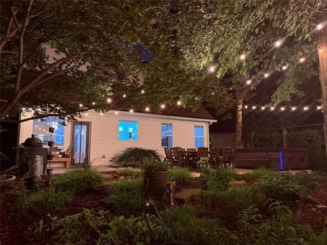 a backyard of a house with garden and outdoor seating