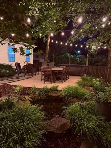 a view of house with backyard and sitting area