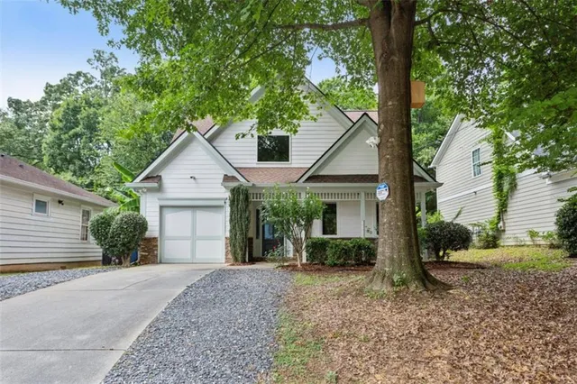 a view of a house with backyard and a tree