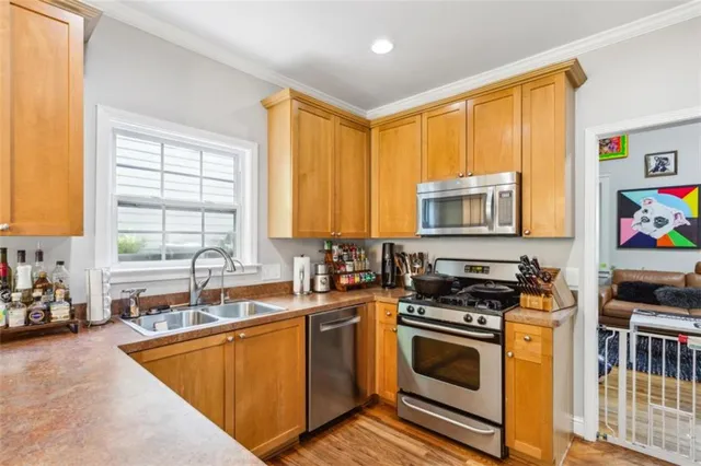 a kitchen with stainless steel appliances granite countertop a stove a sink and a microwave