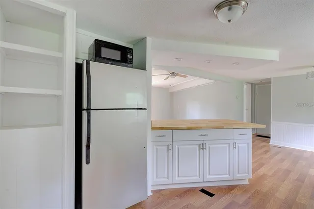 a kitchen with granite countertop a refrigerator a stove a microwave and cabinets