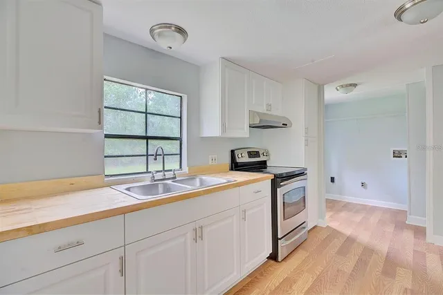 a kitchen with a sink stove and cabinets