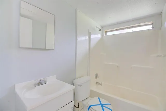 a white bath tub sitting next to a white sink and a shower