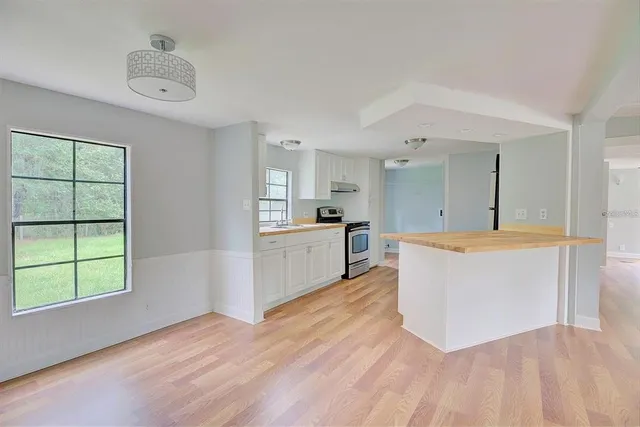 a large kitchen with kitchen island a sink a counter space and a window