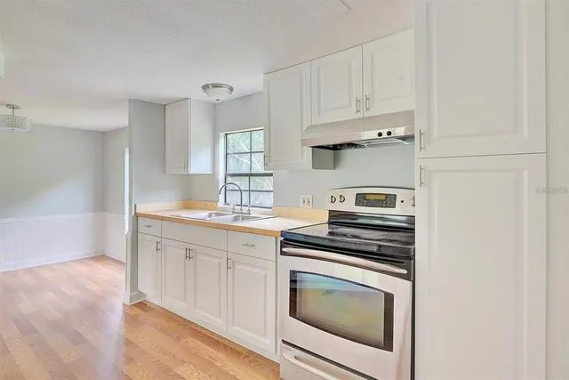 a kitchen with cabinets stainless steel appliances and a counter space