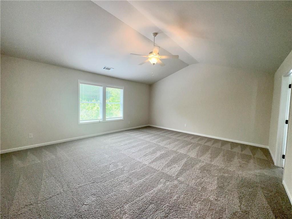 306 Rodeo Drive Auburn, GA 30011 - Photo 20 of 23 an empty room with a chandelier fan and windows