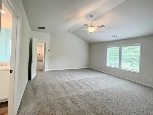 an empty room with ceiling fan and window