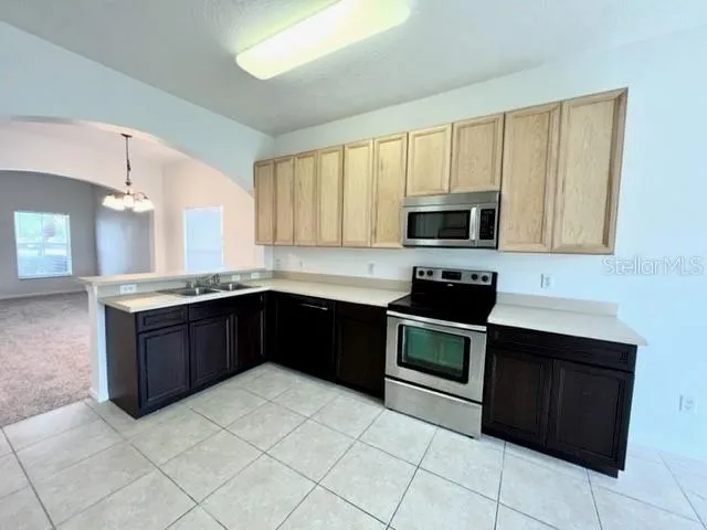 a kitchen with stainless steel appliances granite countertop a stove microwave and sink