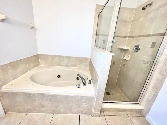 a bathroom with a tub a shower and vanity