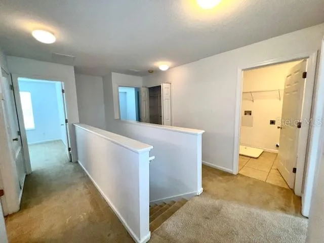 a view of a hallway with bathroom and mirror