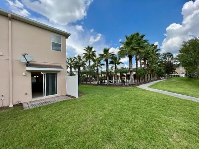 a view of a house with backyard and a tree