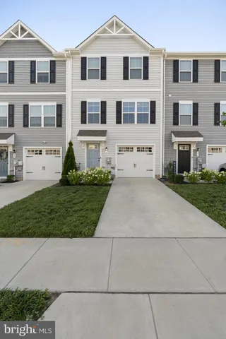 a view of a white house with a yard and plants