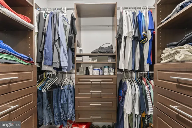 a view of walk in closet with clothes and shoes