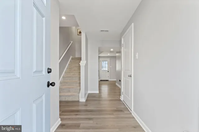 a view of a hallway with wooden floor and staircase
