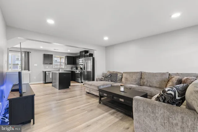a living room with furniture and kitchen view