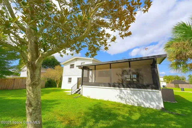 a backyard of a house with plants and tree