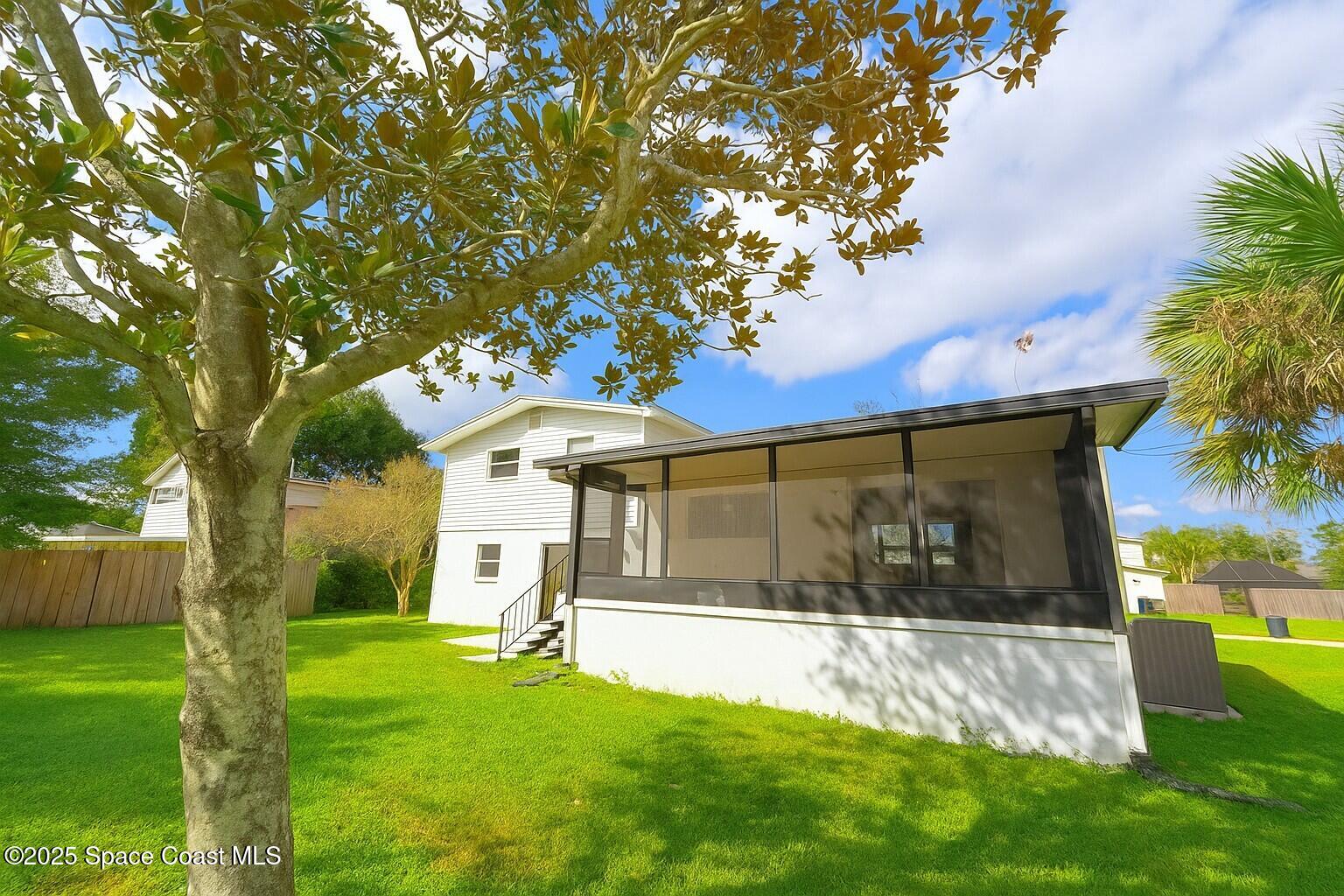 1021 Palmer Road Rockledge, FL 32955 - Photo 21 of 23 a view of a white house with a big yard and large tree