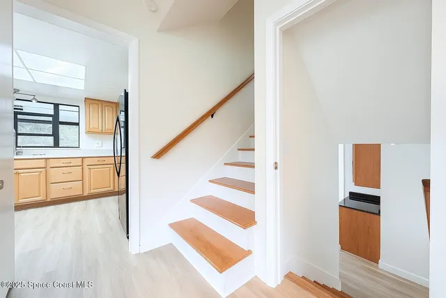 a large kitchen with stainless steel appliances granite countertop a refrigerator a sink dishwasher a stove and a refrigerator with wooden floor