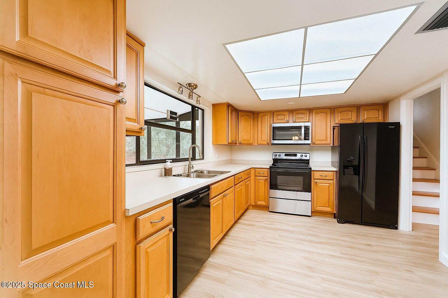 1021 Palmer Road Rockledge, FL 32955 - Photo 7 of 23 a large kitchen with stainless steel appliances granite countertop a refrigerator a sink dishwasher a stove and a refrigerator with wooden floor