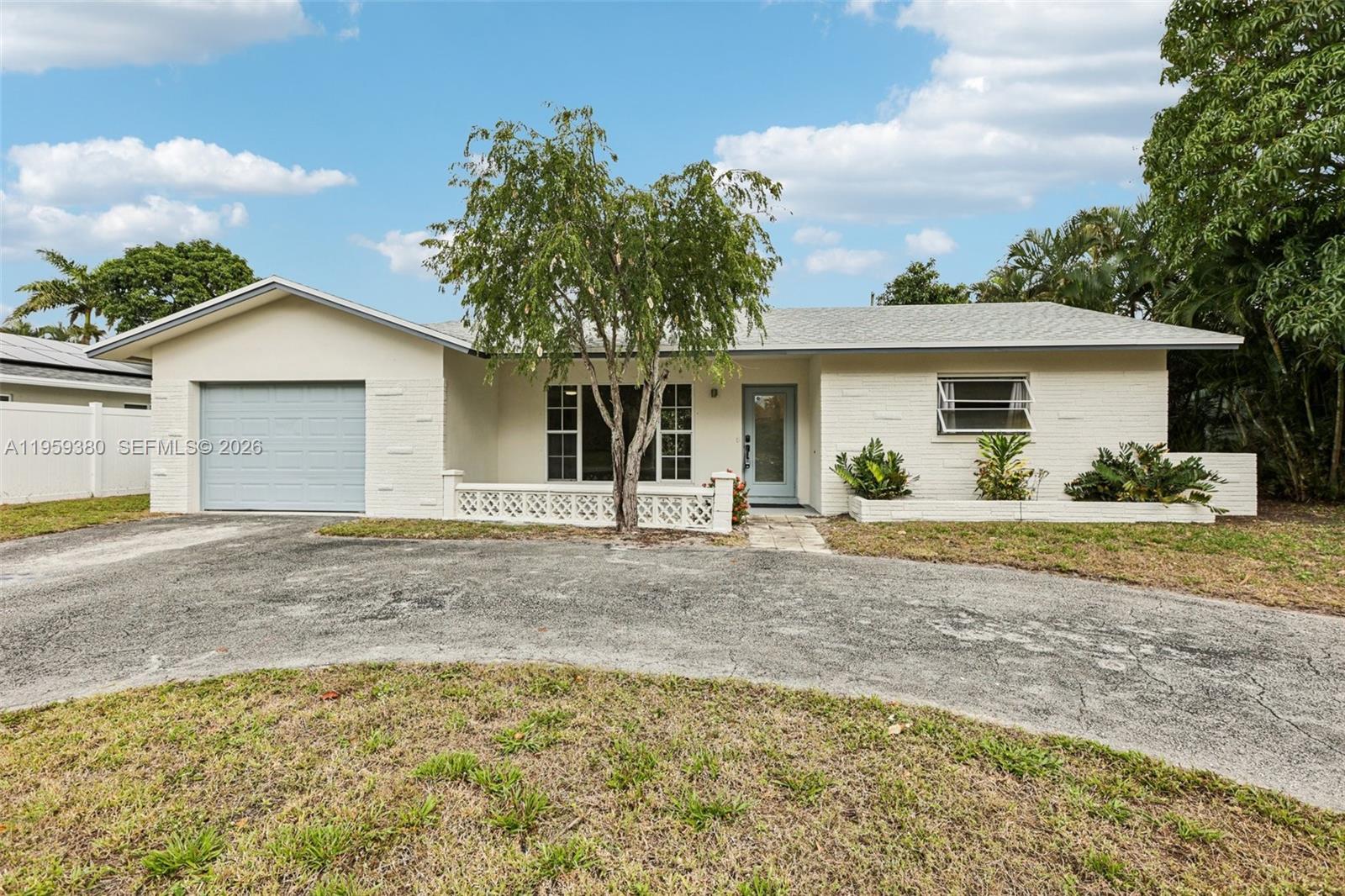 a view of a house with backyard and a tree
