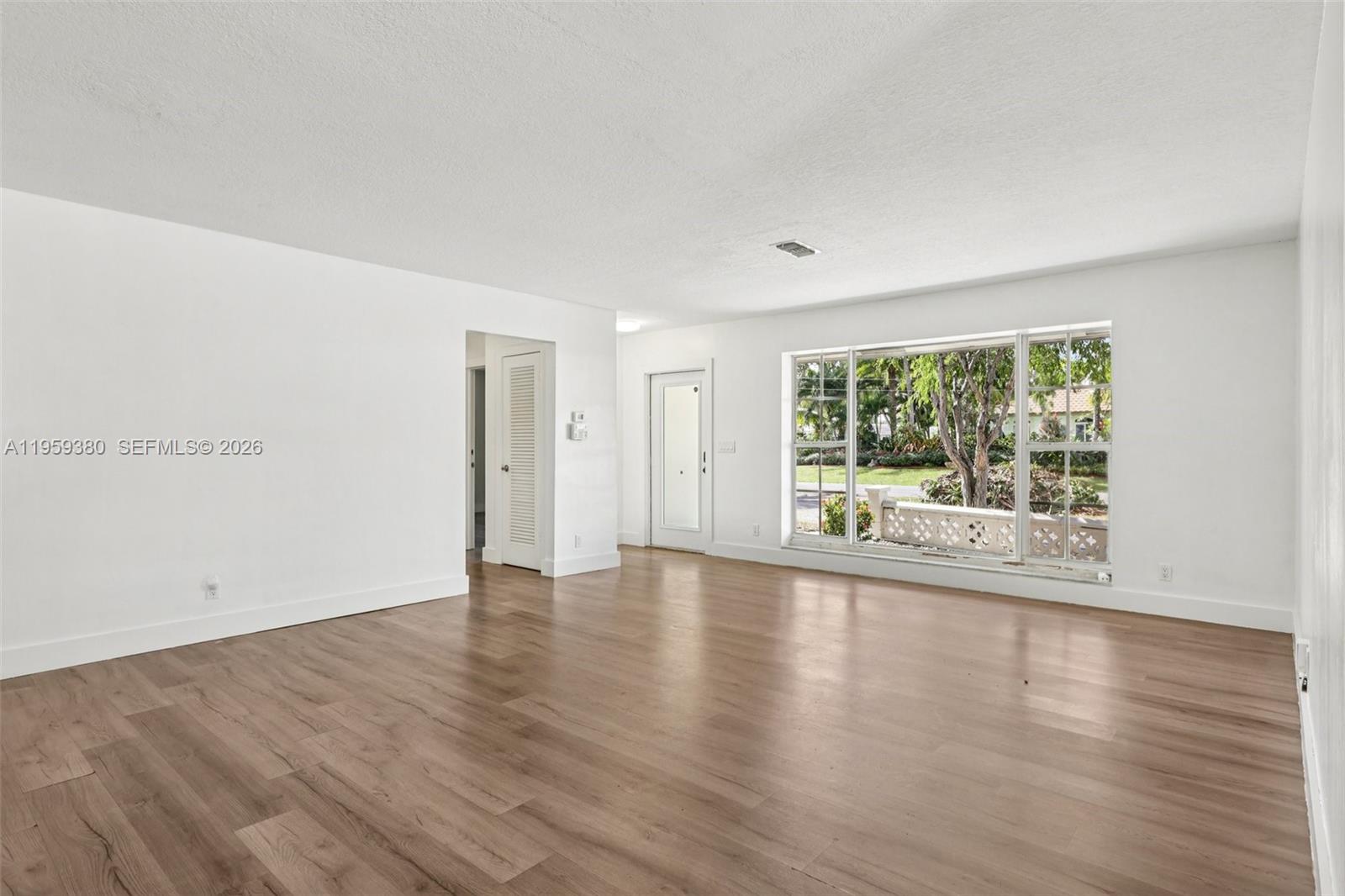 2720 Northeast 25th Terrace Boca Raton, FL 33431 - Photo 11 of 40 a view of empty room with wooden floor and fan