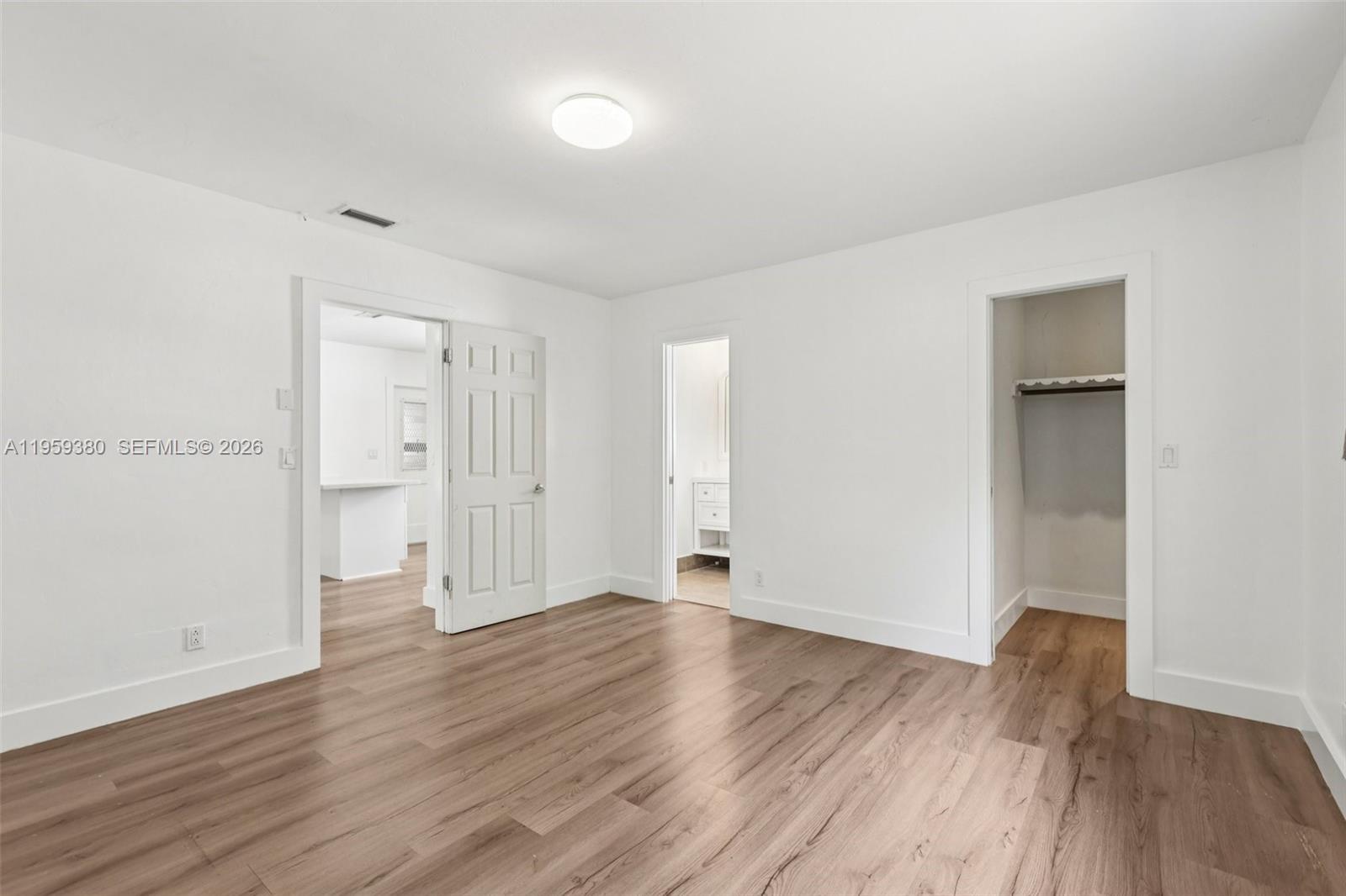 2720 Northeast 25th Terrace Boca Raton, FL 33431 - Photo 18 of 40 a view of an empty room with wooden floor
