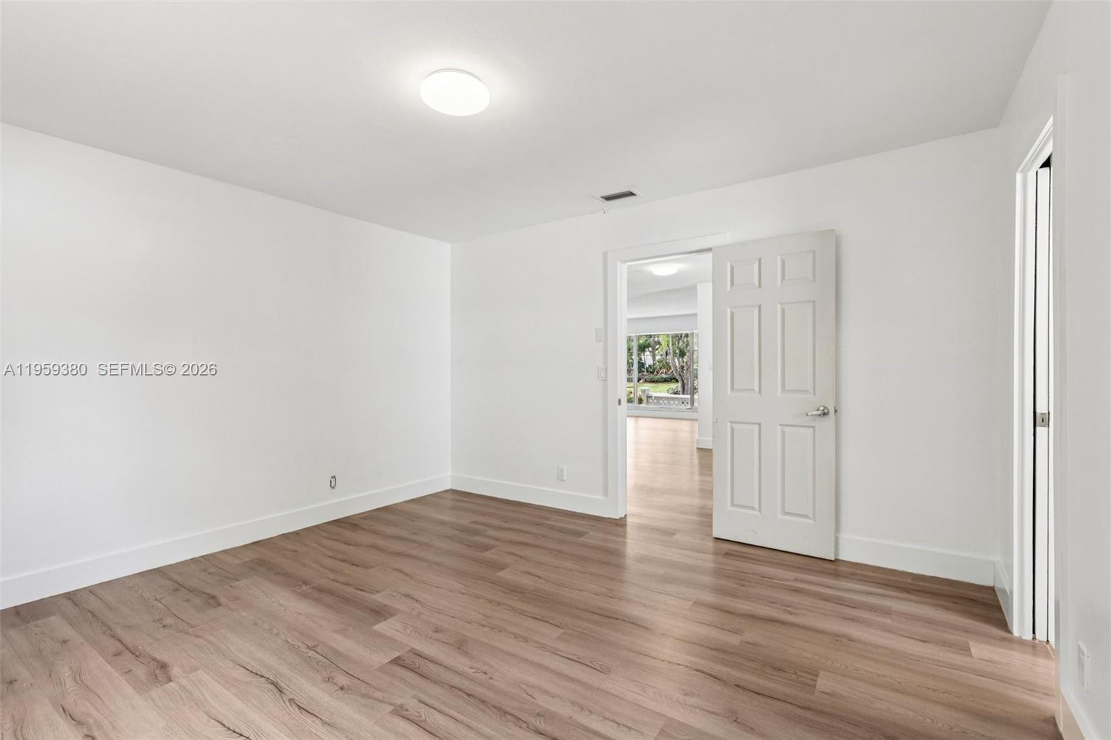 2720 Northeast 25th Terrace Boca Raton, FL 33431 - Photo 19 of 40 a view of an empty room with wooden floor