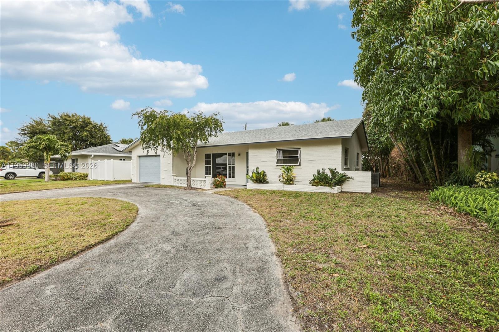 2720 Northeast 25th Terrace Boca Raton, FL 33431 - Photo 2 of 40 a front view of a house with garden