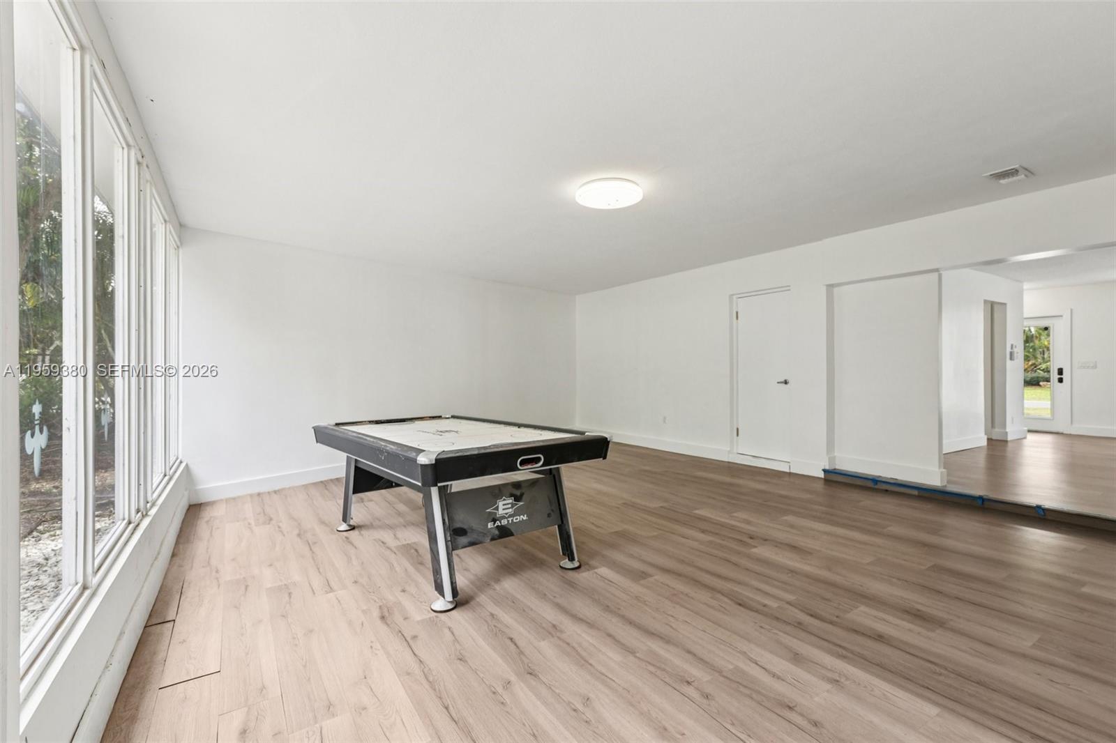 2720 Northeast 25th Terrace Boca Raton, FL 33431 - Photo 23 of 40 a view of a room with wooden floor and glass door