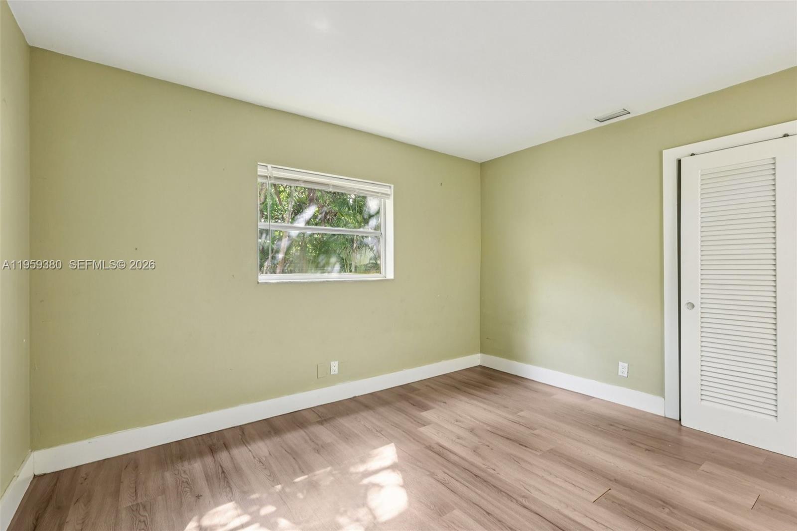 2720 Northeast 25th Terrace Boca Raton, FL 33431 - Photo 30 of 40 an empty room with wooden floor and window