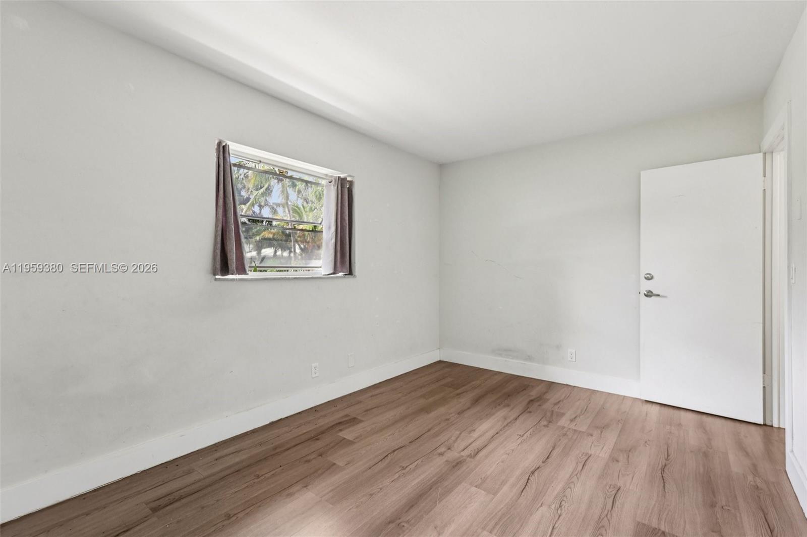 2720 Northeast 25th Terrace Boca Raton, FL 33431 - Photo 35 of 40 a view of empty room with wooden floor and fan