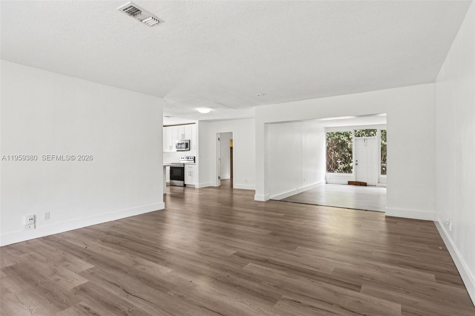 2720 Northeast 25th Terrace Boca Raton, FL 33431 - Photo 8 of 40 an empty room with wooden floor and fireplace