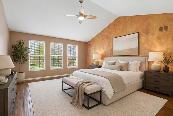 a spacious bedroom with a large bed and a chandelier
