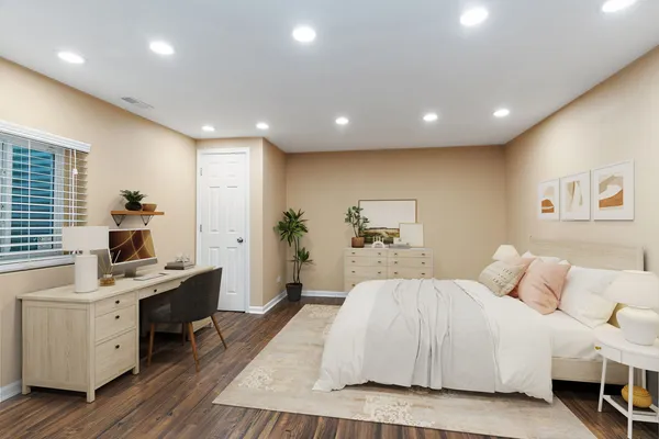 a spacious bedroom with a large bed a desk and chair