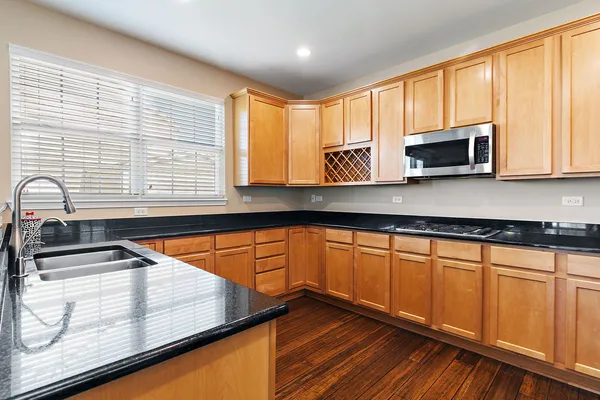 a kitchen with stainless steel appliances wooden cabinets a sink and a microwave