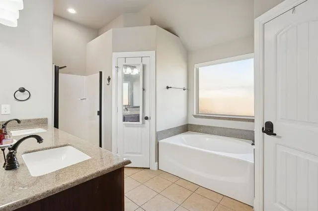 a bathroom with a granite countertop sink tub and a mirror