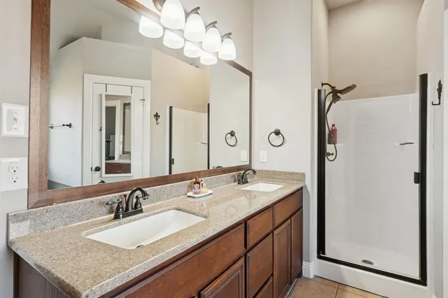 a bathroom with a granite countertop sink a mirror and a shower