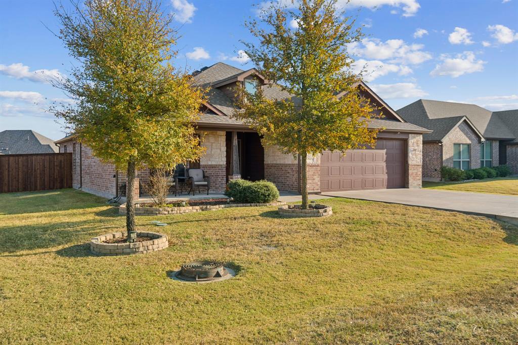 105 Cherry Point Drive Palmer, TX 75152 - Photo 3 of 32 a front view of a house with a yard garage and outdoor seating