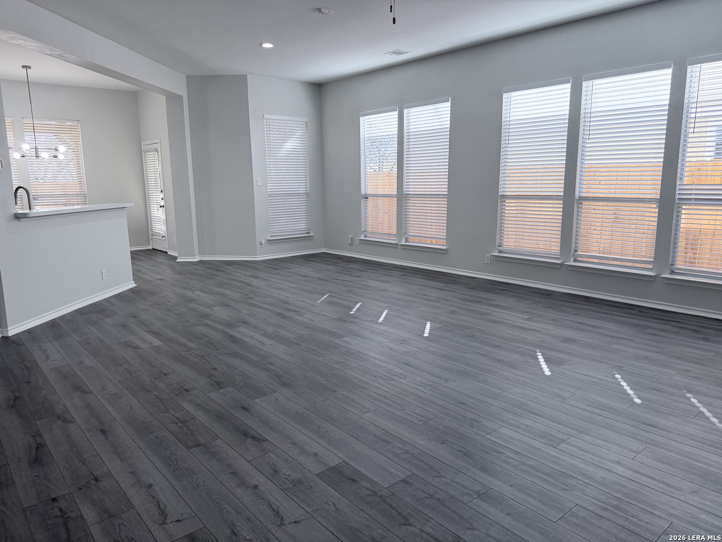 6736 Terra Rye San Antonio, TX 78240 - Photo 2 of 26 an empty room with wooden floor and windows