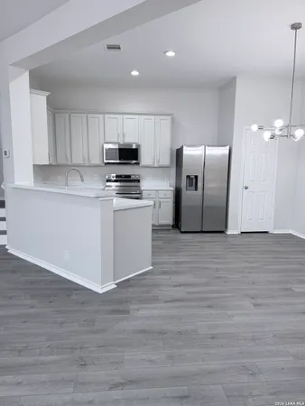 a kitchen with stainless steel appliances granite countertop a refrigerator a stove a sink and a microwave