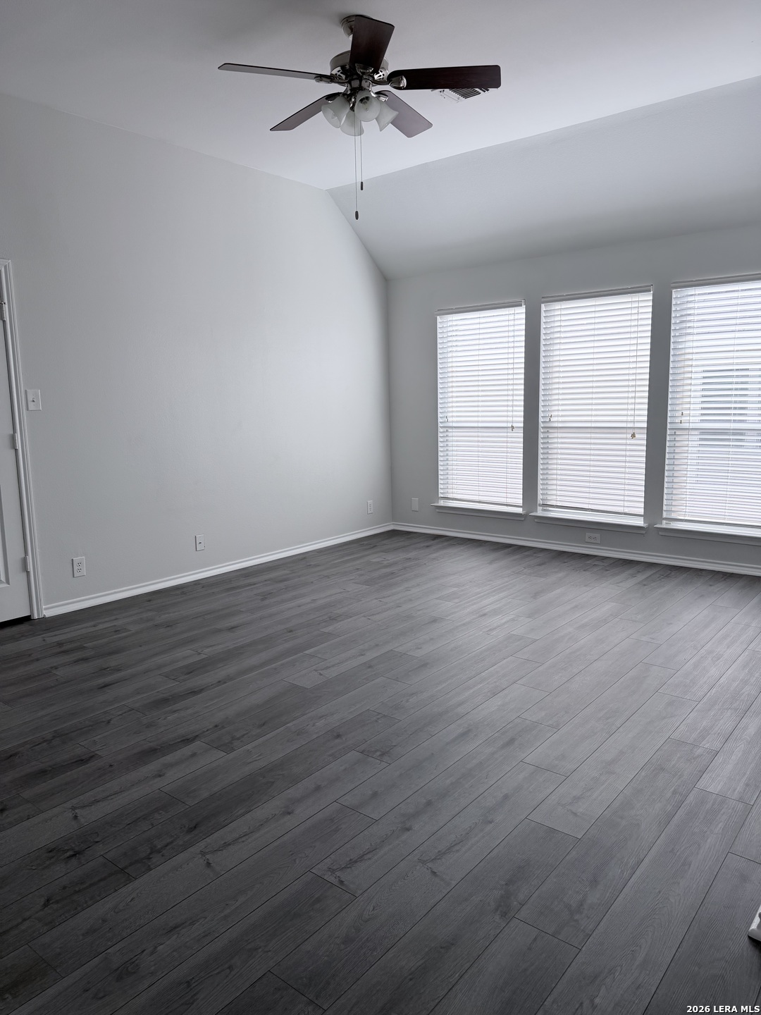 6736 Terra Rye San Antonio, TX 78240 - Photo 9 of 26 an empty room with wooden floor fan and windows