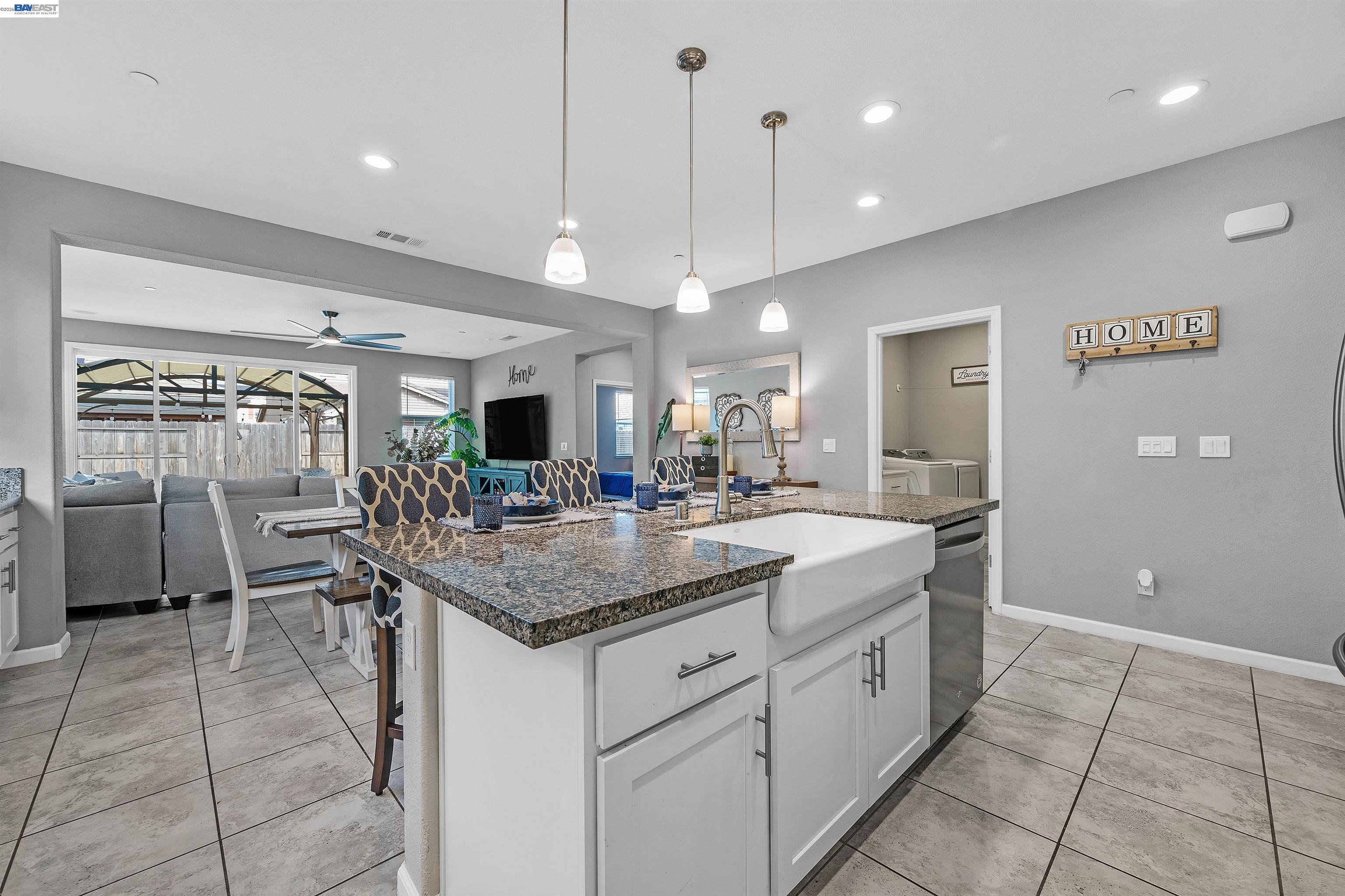 1589 Friendly Street Manteca, CA 95337 - Photo 11 of 50 a kitchen with a sink a counter top space appliances and a view of living room