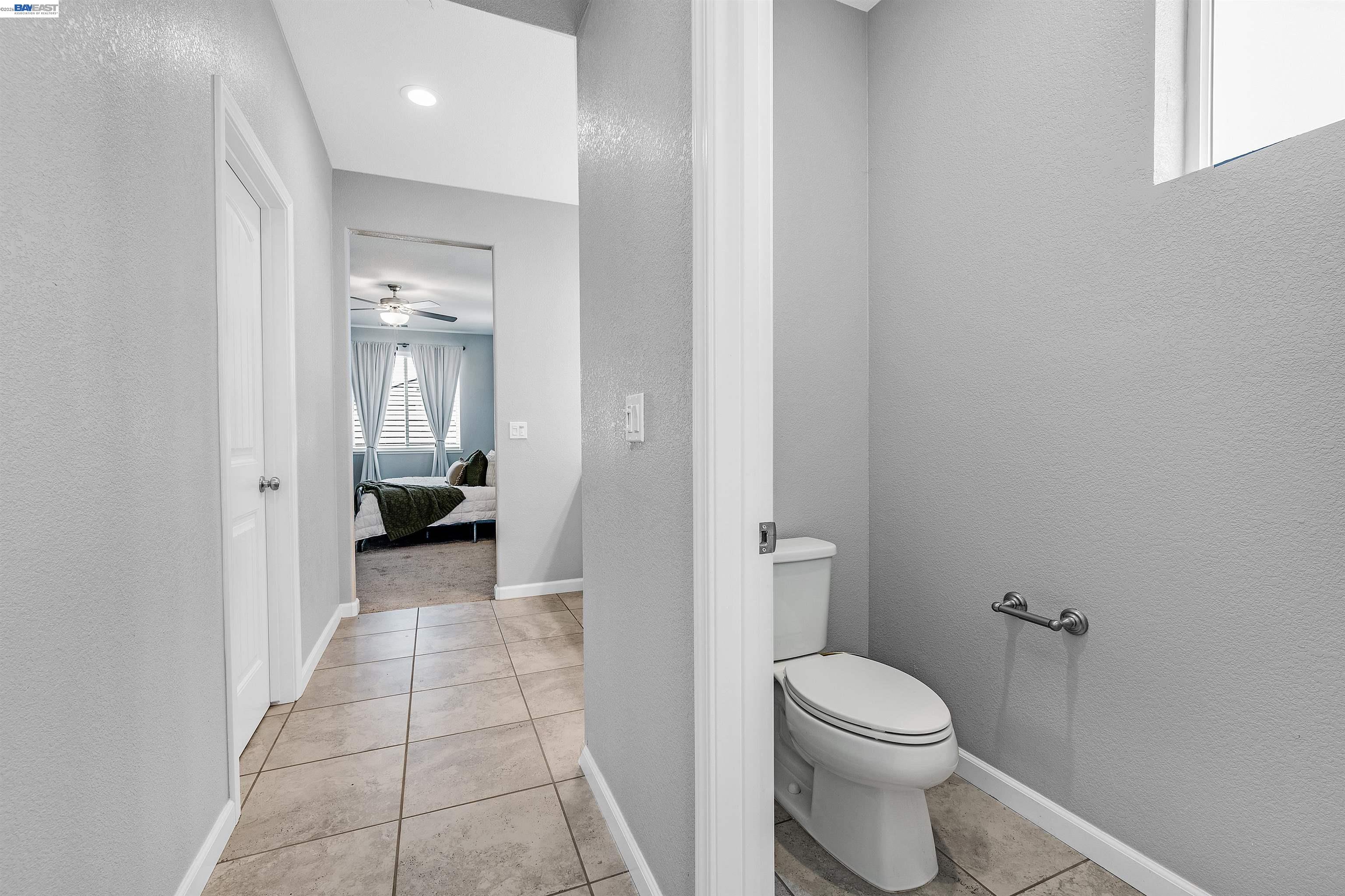 1589 Friendly Street Manteca, CA 95337 - Photo 32 of 50 a bathroom with a granite countertop toilet a sink and a mirror