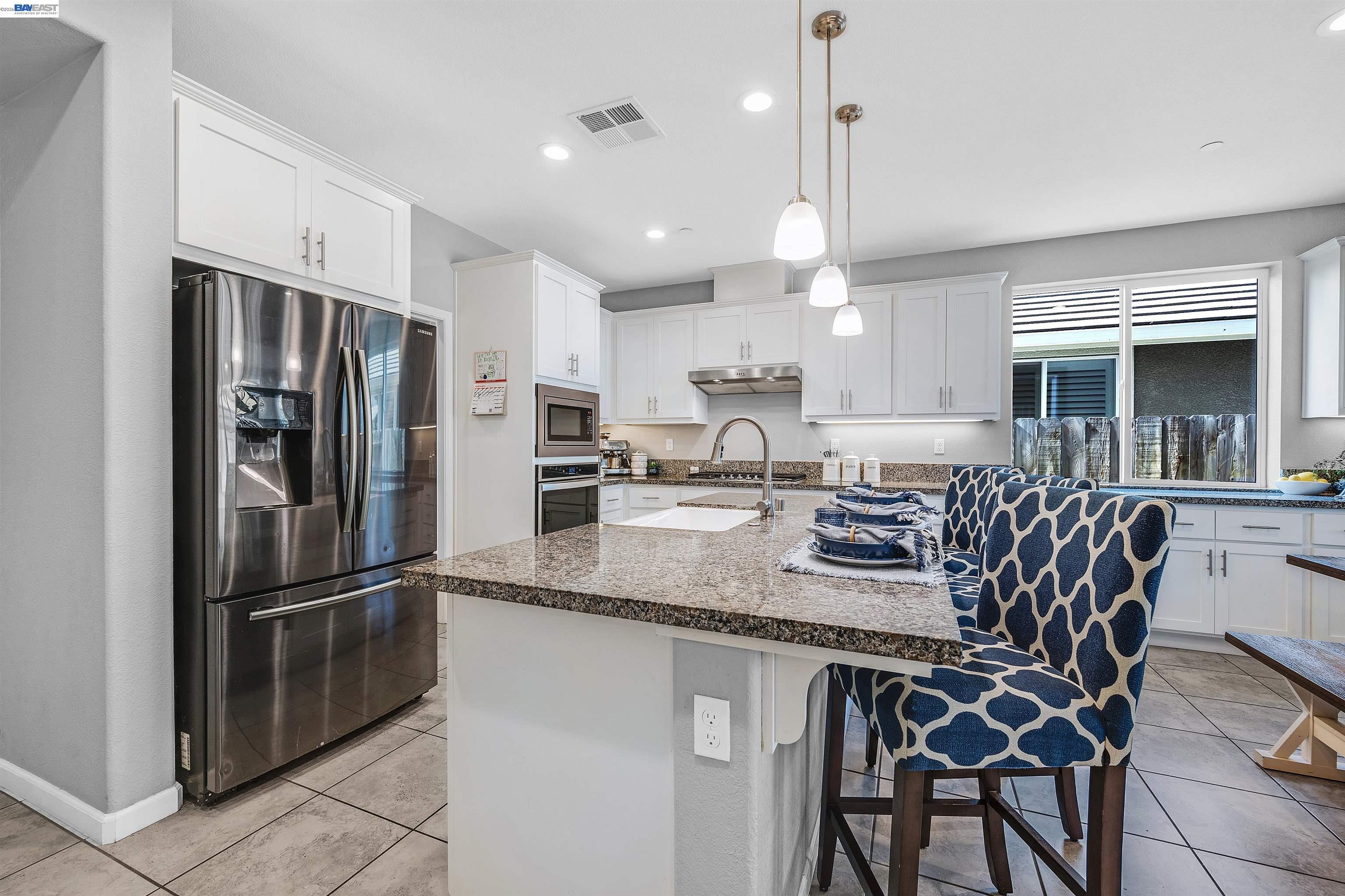 1589 Friendly Street Manteca, CA 95337 - Photo 8 of 50 a kitchen with stainless steel appliances granite countertop a sink refrigerator and microwave