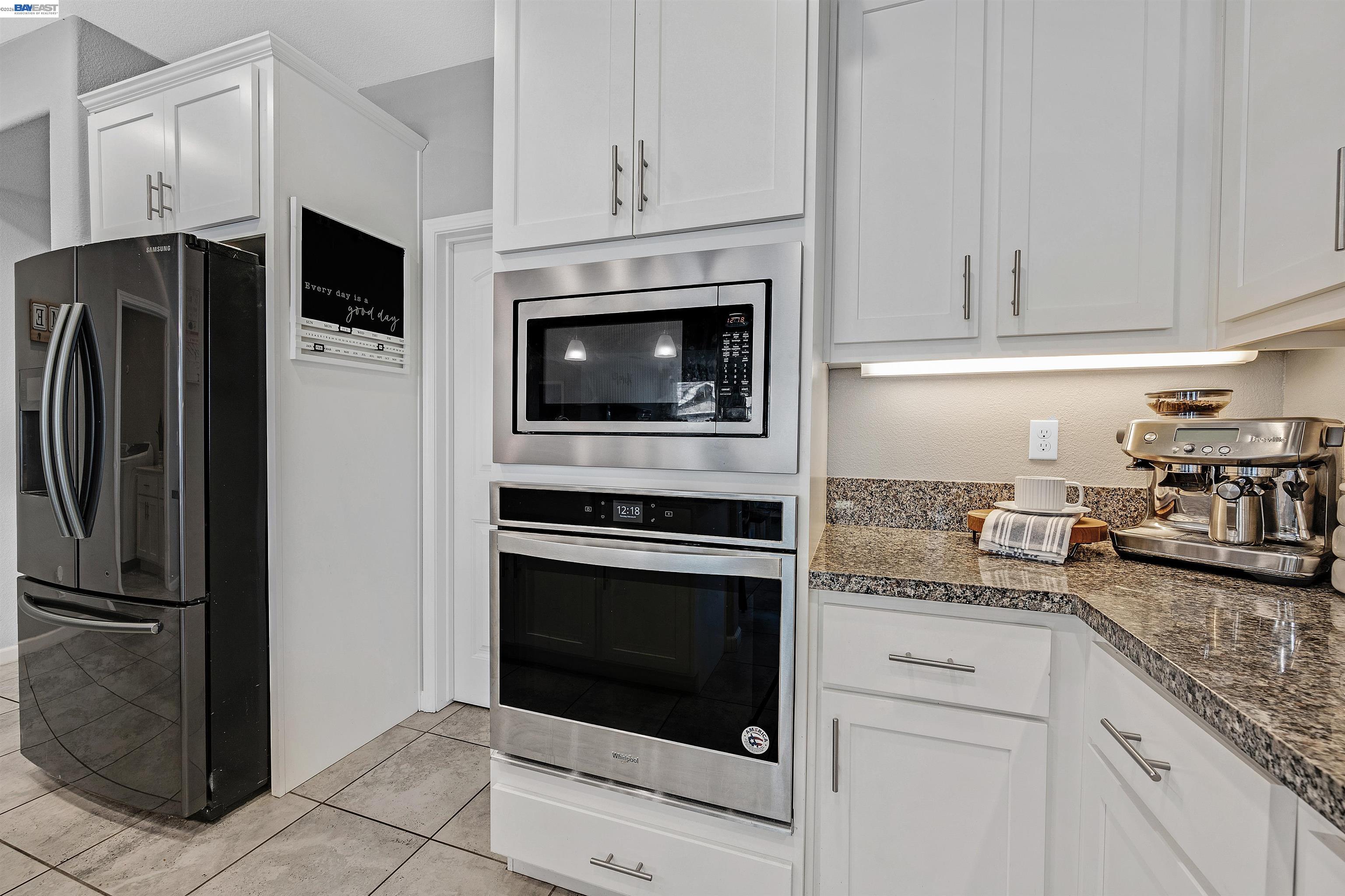 1589 Friendly Street Manteca, CA 95337 - Photo 9 of 50 a kitchen with granite countertop stainless steel appliances a stove a microwave and cabinets