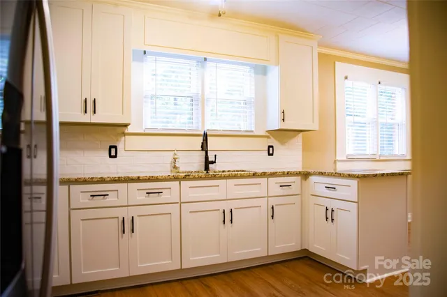 a kitchen with granite countertop white cabinets and white appliances