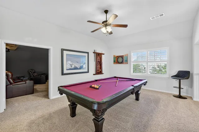 a room with pool table and windows