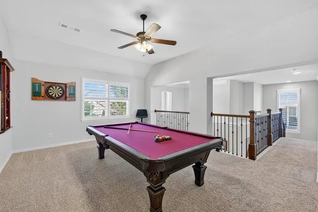 a room with pool table and windows